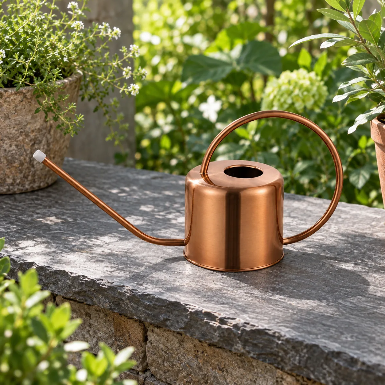 Elevated view of the exact copper-tone can on a garden stone shelf, showing its open top and circular handle